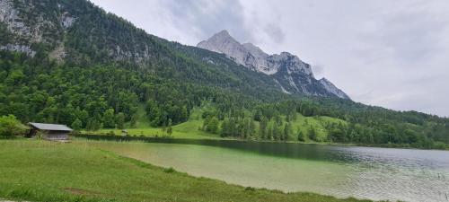 a lake with a house next to a mountain at Haus Posaunenklang in Mittenwald