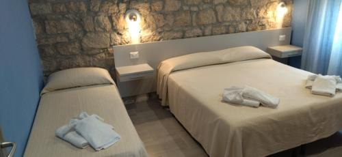 a hotel room with two beds with towels on them at Lungomare Bed rooms in Santa Maria Navarrese