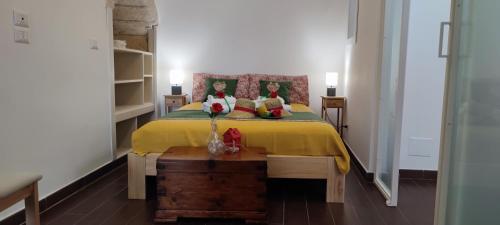 a bedroom with a bed with two dolls on it at Lithos house pt 1p e 2p in Monopoli