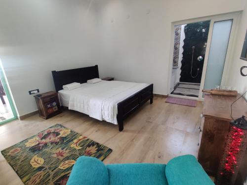 a bedroom with a bed and a couch and a door at The Balified Villa in Puducherry