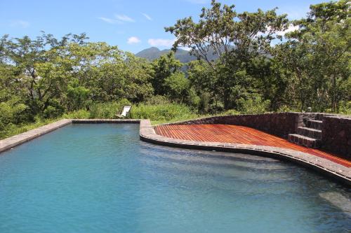 una gran piscina de agua con árboles en el fondo en El Respiro Ecolodge, en Granada