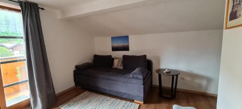 a living room with a couch and a window at Haus Posaunenklang in Mittenwald