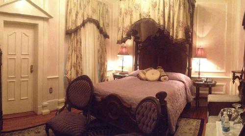 a bedroom with a bed with a teddy bear on it at The Hotel Magnolia in Foley
