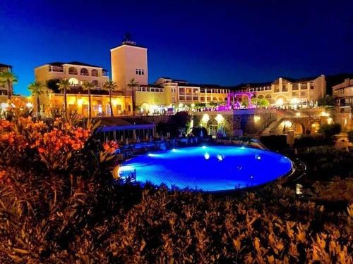 a large blue swimming pool in front of a building at L'écrin du Cap Esterel in Saint-Raphaël