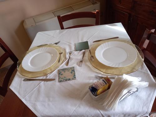 a table with two plates on a white table cloth at BnB Villa Melany vicino Centro in Lucca