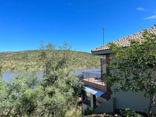 a building with a deck next to a body of water at Fish Eagle Bay 28, Warmbaths in Bela-Bela