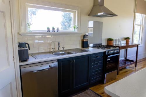 a kitchen with a sink and a stove at Pound Hill Cottage in Miners Rest