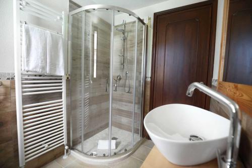 W łazience znajduje się prysznic i biała umywalka. w obiekcie B&B Golf Club Le Vigne w mieście Villafranca di Verona