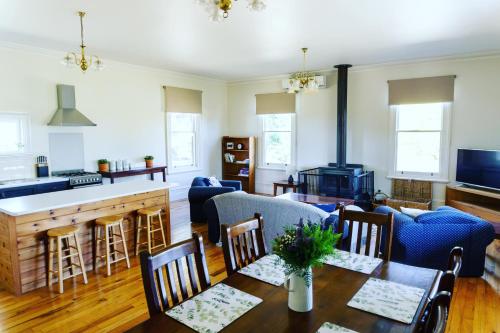 a living room with a table and a kitchen at Pound Hill Cottage in Miners Rest