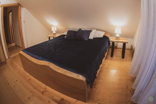 a bedroom with a large bed with two lamps on two tables at Stara Chata w Beskidach in Żabnica