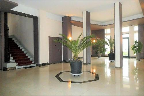 a large lobby with a potted plant in the middle at Grand studio 38m2 dans ancien palace avec piscine et place de parking privée in Aix-les-Bains