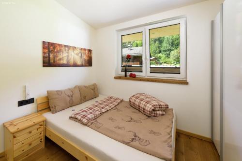 Habitación pequeña con cama y ventana en Apartment Melina, en Neukirchen am Großvenediger