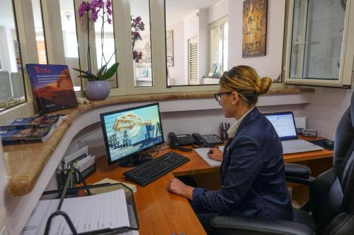 a woman sitting at a desk with a computer at Etna Royal View in Trecastagni