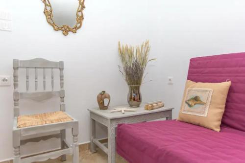 un soggiorno con divano viola e tavolo di Villa Galante, (croft house nearby the sea) a Naxos Chora