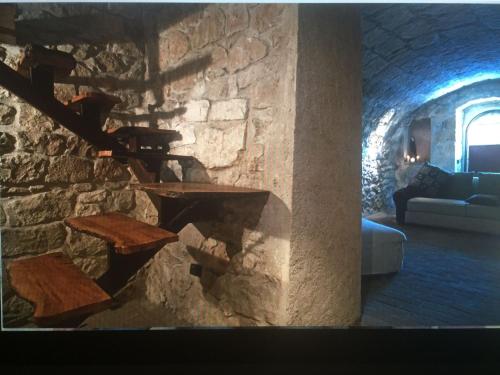 een woonkamer met een stenen muur en een open haard bij La pietra in Roccamorice