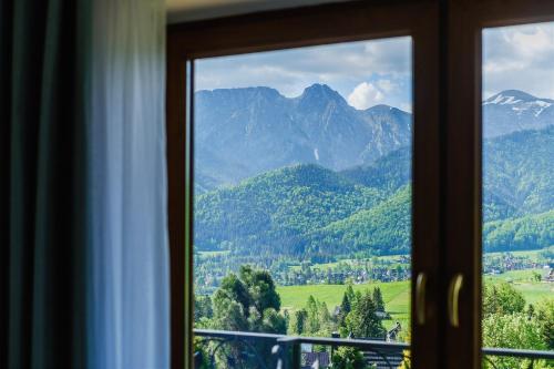 a window with a view of a mountain view at Pokoje i apartament z widokiem na Tatry in Kościelisko
