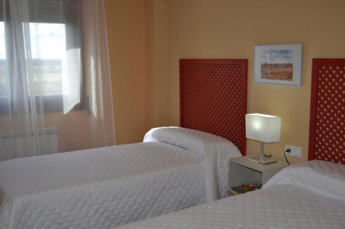 a hotel room with two beds and a window at Tordesillas, Miralduero in Tordesillas