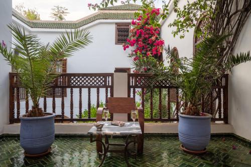 a room with a table and two potted plants at Riad Alma in Marrakech