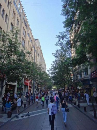 a group of people walking down a city street at Hotel Libertador in Santiago