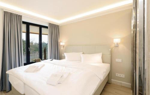 una camera da letto con un grande letto bianco con cuscini bianchi di Prince a Binz