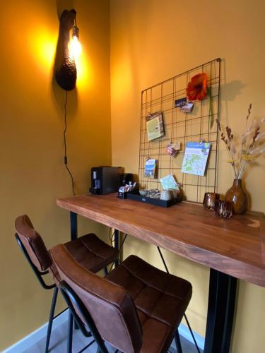 a room with a desk with two chairs and a table at Domestico Bed & Breakfast in Lage Mierde