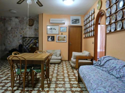 uma sala de estar com uma mesa e um sofá em 100 passi dal mare em Isola delle Femmine