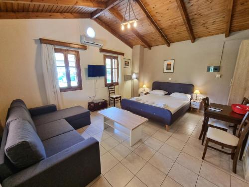 a living room with a couch and a bed at Alexaria Holidays Homes in Lefkada