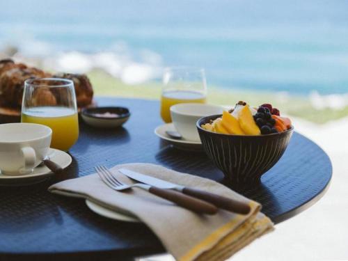 uma mesa com uma taça de fruta e sumo de laranja em Sala Beach House em Ballito