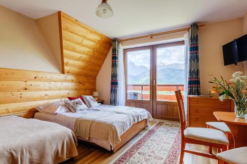 1 dormitorio con 2 camas y ventana en Pokoje i apartament z widokiem na Tatry en Kościelisko