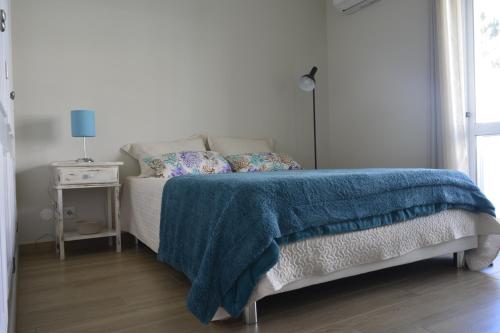 a bedroom with a bed with a blue blanket on it at Apartamento Azul in Quarteira