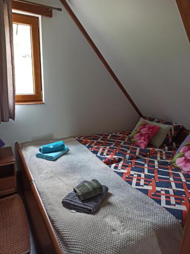 a bed with two towels on it in a room at Dolina Rosy in Ustrzyki Dolne