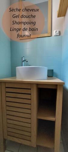 a bathroom with a sink and a sign on the wall at NOUVEAU : Rustik'House - À 2 pas de la Gare RER C in Breuillet