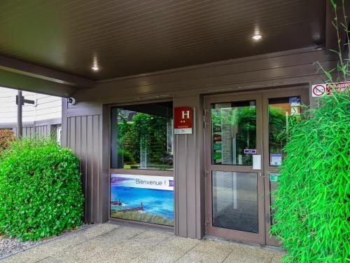 an entrance to a building with two glass doors at Hotel Ibis Budget Fecamp in Fécamp