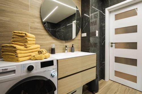 La salle de bains est pourvue d'un lave-linge et d'un miroir. dans l'établissement FLEXIHOME SK - Tolsteho - Free Parking on the street - 2 bedrooms, à Košice