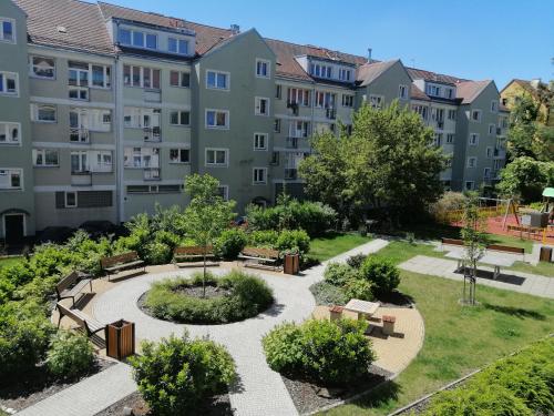 an apartment complex with a park with benches and trees at Apartament w Centrum in Szczecin