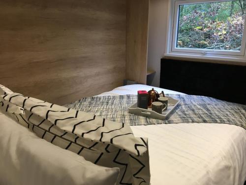een slaapkamer met een bed met een dienblad met eten erop bij P57 - Riverside Family Pod with Hot Tub in Bethesda