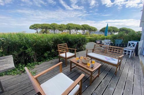 - une terrasse avec 2 chaises et une table avec des boissons dans l'établissement La Lagune - terrace and parking, au Grau-du-Roi