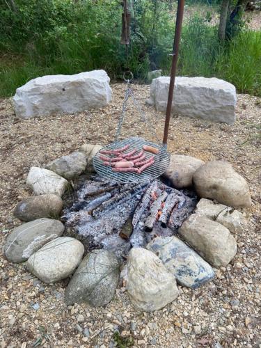 - un foyer extérieur avec des rochers et un parasol dans l'établissement Camp du Père Castor, à Simard