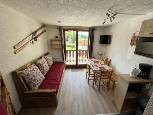 un salon avec un canapé et une table dans l'établissement Grand Studio, aux Carroz d'Arâches