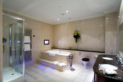La salle de bains est pourvue d'une baignoire, d'un lavabo et d'une douche. dans l'établissement Macdonald Norwood Hall Hotel, à Aberdeen