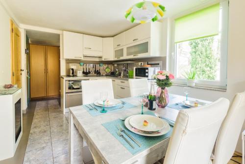 a kitchen with a dining table and white cabinets at JMJ Green view in Piran