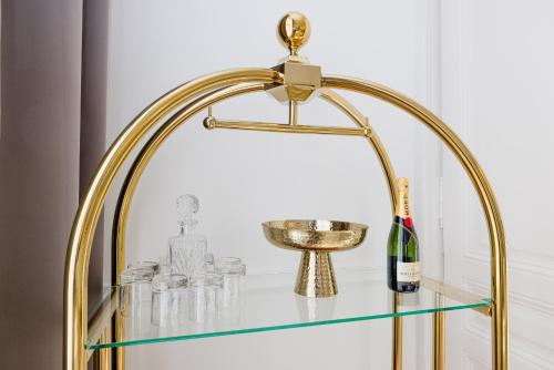 a gold and glass table with a bottle of champagne at RAFAEL KAISER - Premium Apartments City Centre - Contactless Check-In in Vienna