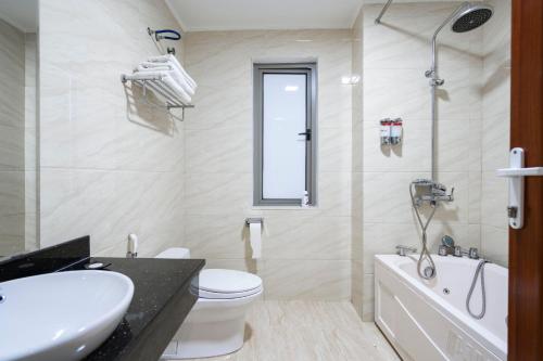 a bathroom with a sink and a toilet and a tub at LUXURY HOTEL in Ha Long