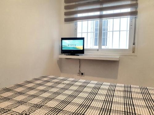 une chambre avec une télévision assise sur un rebord de fenêtre dans l'établissement Precioso apartamento con estilo., à Almería