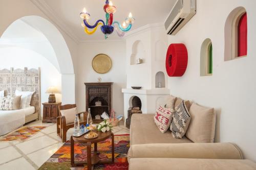 a living room with a couch and a chandelier at Riad Alma in Marrakech