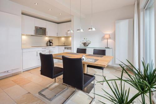 una cucina e una sala da pranzo con tavolo e sedie in legno di Penthaus 14 Strandvilla Therese a Norderney