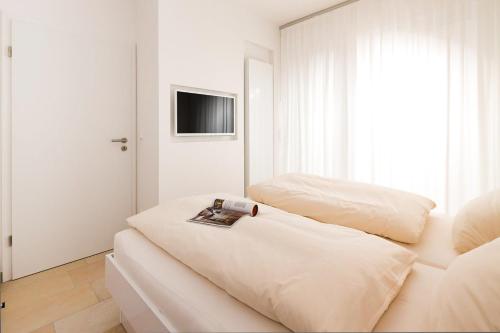 Camera bianca con 2 letti e una TV di Penthaus 14 Strandvilla Therese a Norderney