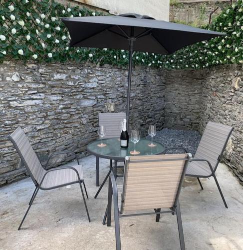 stół i krzesła z parasolem i kieliszkami do wina w obiekcie No. 22 w mieście Londonderry/Derry