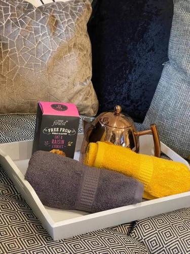 a tray with towels a tea kettle and a book at P76 - Riverside Family Pod with Hot Tub in Bethesda