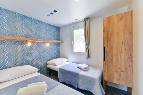 um quarto com duas camas e uma janela em Adria Nova kamp Laguna em Turanj